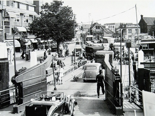 K-8 van W.J.L. de Groof uit Kruiningen, rijdt van de pont aan het Blauwpoortplein te Dordrecht, juni 1939.
Bron: Regionaal Archief Dordrecht, Foto 555_10170.  Fotograaf J.L. du Parant, collectie W. Meijers.
